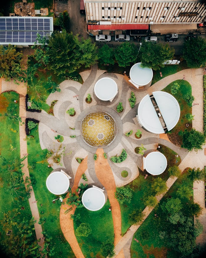 Aerial shot of a modern, futuristic garden with geometric pathways and circular structures.
